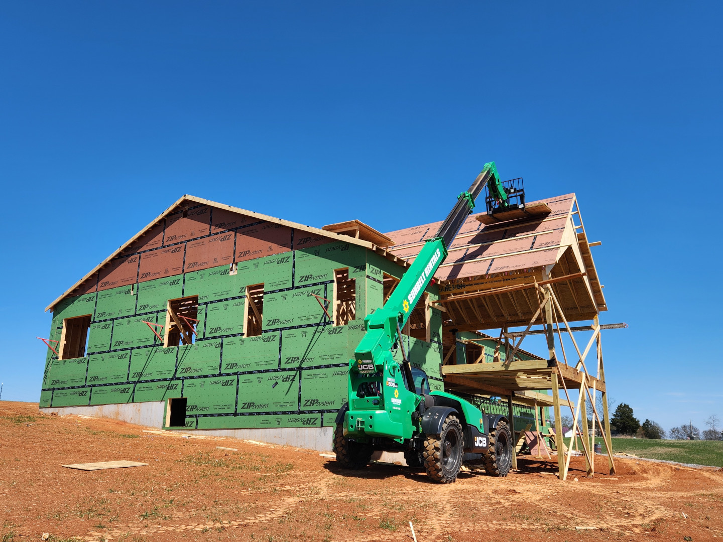 Telehandler raising plywood for roof sheathing in Limestone.